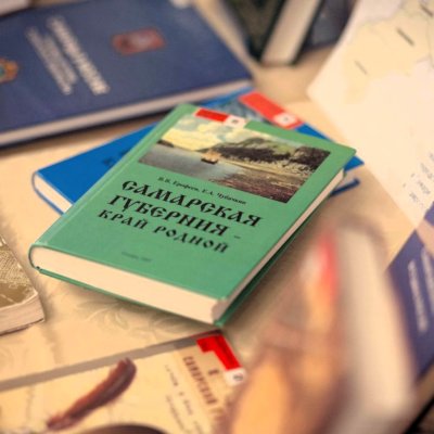 На фотографии стопки книг и раскрытая книга